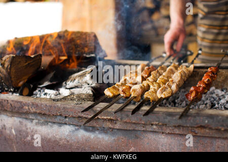 Shish kebab in processo di cottura sul fuoco aperto all'aperto Foto Stock