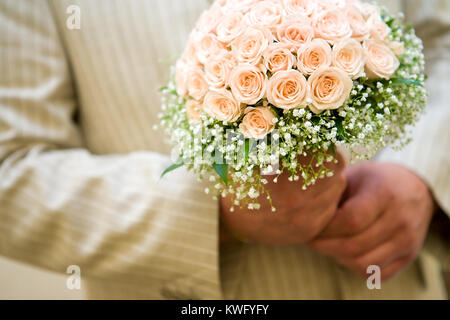 Lo sposo holding sposa bouquet close up Foto Stock