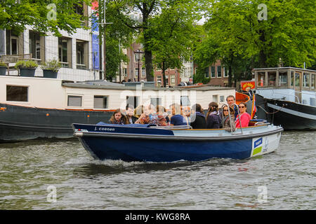 Amsterdam, Paesi Bassi - 20 Giugno 2015: la gente in barca a un tour dei canali di Amsterdam Foto Stock