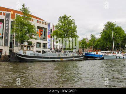 Amsterdam, Paesi Bassi - 20 Giugno 2015: Embankment e le navi da vicino il Palazzo Nazionale di opera e balletto in Amsterdam Foto Stock