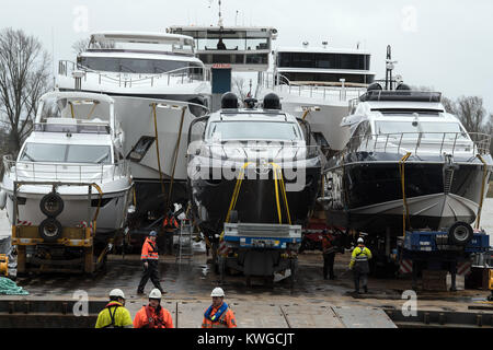 Duesseldorf, Germania. 03 gen 2018. Lavoratori scaricare una 21-metro-lunga Ferretti Pershing 70 yacht di lusso (C) da un pontone a Duesseldorf in Germania, 03 gennaio 2018. Più di 1800 espositori provenienti da più di 60 paesi presenti innovazioni del mondo degli sport acquatici tra 20 e 28 gennaio. Credito: Federico Gambarini/dpa/Alamy Live News Foto Stock