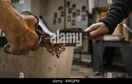 Davenport, Iowa, USA. Xxi Dec, 2016. Joel Ryser, il dipartimento arte direttore presso Moline High School e Mark Van Osdel di Le Claire lavorano insieme per rompere le estremità di un pezzo di vetro caldo studio in Davenport Mercoledì, Dicembre 21, 2016. Joel Ryser corre vetro caldo, una organizzazione non profit e business a Davenport che offre gratuitamente la soffiatura del vetro alle classi di veterani e a rischio i bambini. Credito: Andy Abeyta/Quad-City volte/ZUMA filo/Alamy Live News Foto Stock