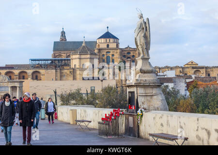 Cordoba, Spagna. Statua di San Rafael patrono sul ponte romano, la grande moschea in background. Foto Stock