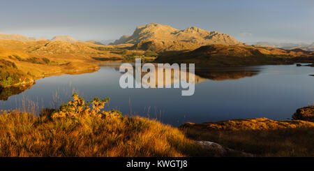 Sunset over Beinn Airigh Charr e Kernsary dall'estremità occidentale del Loch Kernsary. I picchi di Fisherfield Torridon e sono visibili in lontananza. Foto Stock