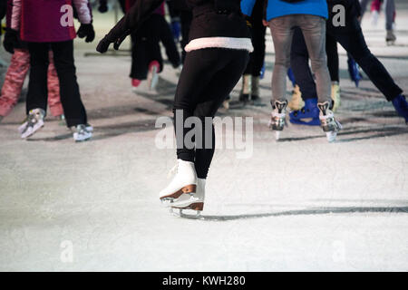 Non identificabili dei pattinatori di ghiaccio utilizzando una pista di pattinaggio temporanea durante il Natale e Anno Nuovo periodo di vacanza Foto Stock