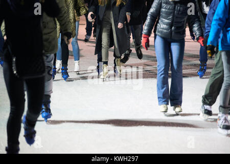 Non identificabili dei pattinatori di ghiaccio utilizzando una pista di pattinaggio temporanea durante il Natale e Anno Nuovo periodo di vacanza Foto Stock