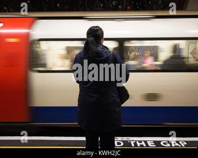 La donna resta in attesa presso la stazione della metropolitana di avvicinamento il treno. Foto Stock