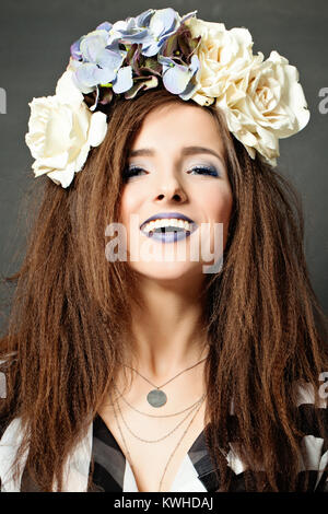 Donna creativa con il trucco di moda e fiori Foto Stock