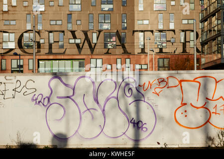 Graffiti "throwups' verniciato a spruzzo arte di strada per lo sviluppo la palizzata pannelli nel nuovo quartiere di Islington, East Manchester Foto Stock