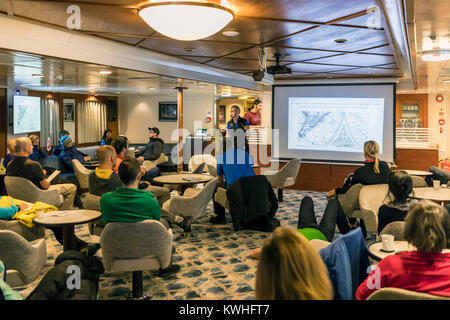 Quark Expeditions presentatori nella lounge; nave passeggeri Ocean Adventurer porta alpine sci alpinismo in Antartide Foto Stock