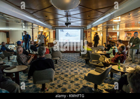 Quark Expeditions presentatori nella lounge; nave passeggeri Ocean Adventurer porta alpine sci alpinismo in Antartide Foto Stock