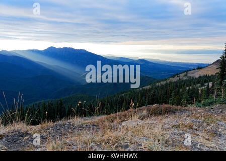 Sole che tramonta dietro le montagne olimpiche sul Parco nazionale di Olympic, Washington Foto Stock