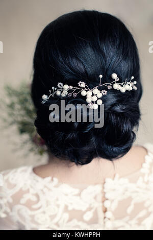 Bridal o Prom Hairstyle con perle bianche Hairdeco su capelli neri di Brunette Donna Foto Stock