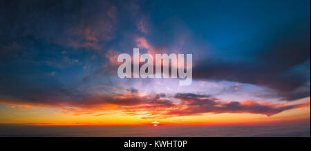 Voli tra la nuvola al tramonto Foto Stock