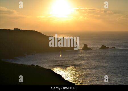 Tramonto sull'oceano su un giorno inverni a Lands' End in Cornovaglia Foto Stock