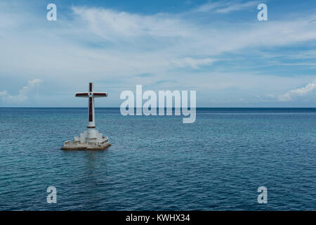 Grande Croce che indica il santuario affondata nel cimitero Camiguin, Filippine Foto Stock