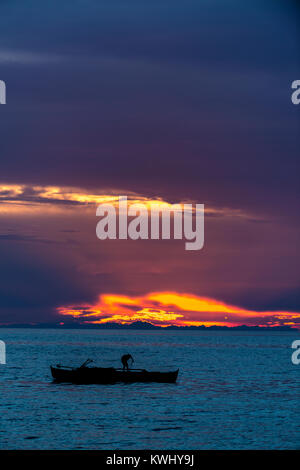 Fisherman trattura nelle sue reti al tramonto Foto Stock