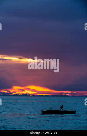 Fisherman trattura nelle sue reti al tramonto Foto Stock