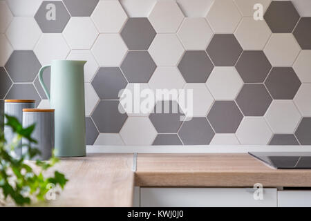 Cucina con il grigio e il bianco parete alveolare piastrelle e piano di lavoro in legno, Foto Stock