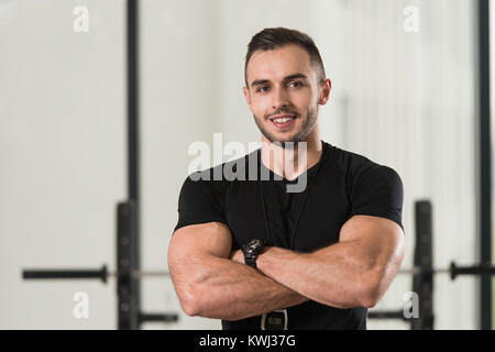 Bello Personal Trainer con il cronometro in un centro fitness Palestra  forte permanente Foto stock - Alamy