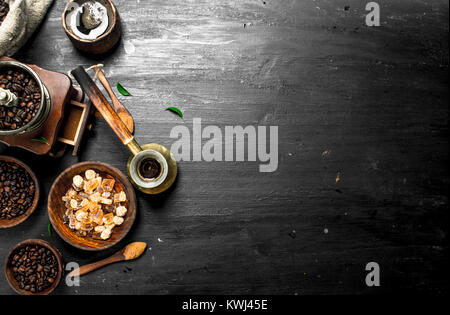 Sfondo di caffè. Il caffè fresco con cristalli di zucchero e i chicchi di caffè. Sulla lavagna. Foto Stock