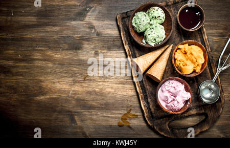 Frutta fresca gelato con waffle tazze. Su un tavolo di legno. Foto Stock