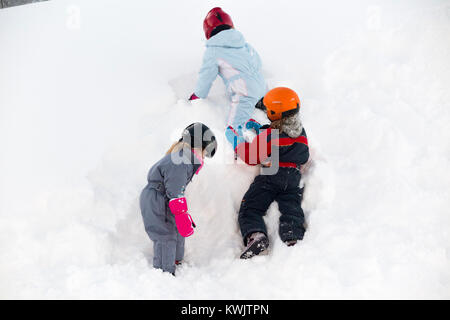 Bambino / bambini / bambino / bambini / tre sorelle di età compresa tra i 35 e sette anni salire una parete di neve che ha deviato in un cumulo di neve. (93) Foto Stock