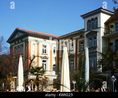 Una vista panoramica del lungolago di Überlingen, Germania, che mostra la passerella lungo il lago di Costanza con alberi, panchine e architettura circostante. Foto Stock