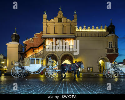 Carrozza a cavallo parcheggiato di fronte panno gotico Hall Sukiennice sulla Piazza del Mercato di Cracovia di notte Foto Stock