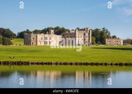 Vista dell'esterno del Castello di Leeds, vicino a Maidstone, Kent, sud-est Inghilterra, Regno Unito su una soleggiata giornata estiva con cielo blu e riflessi in acqua di lago Foto Stock