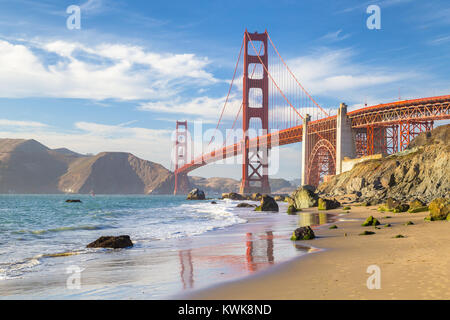 Classic vista panoramica del famoso Golden Gate Bridge visto da scenic Baker Beach in beautiful Golden luce della sera in una giornata di sole con cielo blu e cl Foto Stock