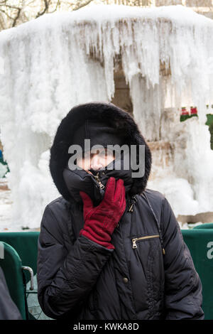 Senior Donna di fronte congelata di Josephine Shaw Lowell fontana commemorativa in Bryant Park, New York, Stati Uniti d'America Foto Stock