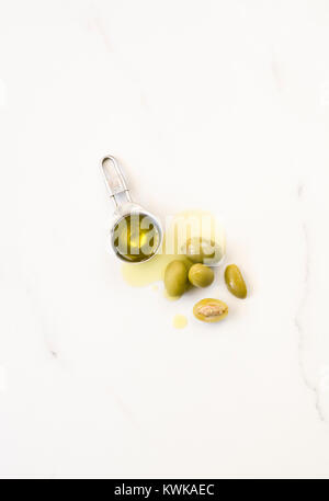 Olio di oliva e di olive su un piano di marmo. Foto Stock