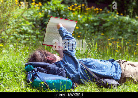 Il lettore che legge un libro nel parco, l'uomo di attività ricreative della Repubblica Ceca legge un libro all'aperto Foto Stock