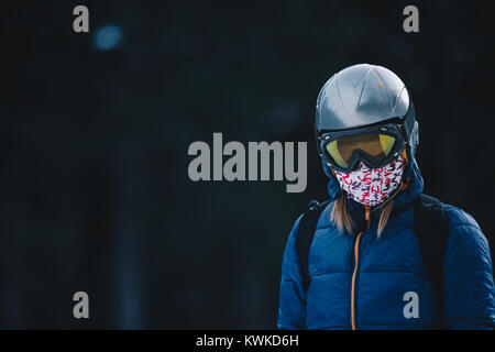 Snowboarder moda ritratto nella foresta di congelato. Donna che indossa maschera di occhiali da sole e buff. Ritratto di donna dello sciatore in montagna Foto Stock
