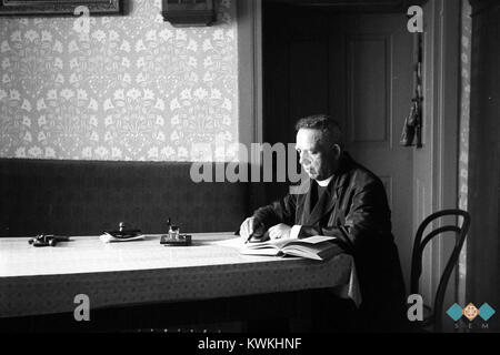 Una fotografia storica di Anton Mrkun scattata nel 1933, che lo mostra seduto a un tavolo. L'immagine fornisce uno sguardo sulla vita slovena e sulla documentazione personale dei primi anni del XX secolo. Foto Stock
