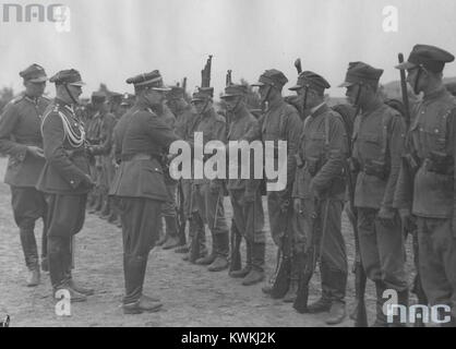 L'immagine mostra Zygmunt Čadek che fissa una medaglia sull'uniforme di un soldato durante una cerimonia di premiazione formale, riflettendo le pratiche d'onore militari. Foto Stock