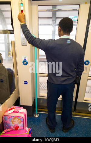 Il conduttore del treno il funzionamento della porta di guardia di chiusura / apertura pulsante sulla Docklands Light Railway servizio del treno (93) Foto Stock
