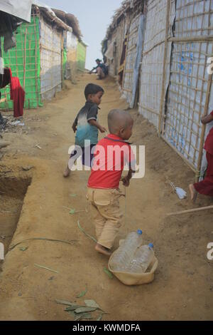 Novembre 22, 2017 - Cox's Bazar, Bangladesh - Rohingya boy visto che trasportano acqua potabile bottiglie al campo profughi.Oltre 600.000 Rohingya rifugiati sono fuggiti dal Myanmar Stato di Rakhine fin dal mese di agosto 2017, come la maggior parte di loro di tenere cercando di attraversare la frontiera per raggiungere il Bangladesh ogni giorno. Credito: Asif Ahmed/SOPA/ZUMA filo/Alamy Live News Foto Stock