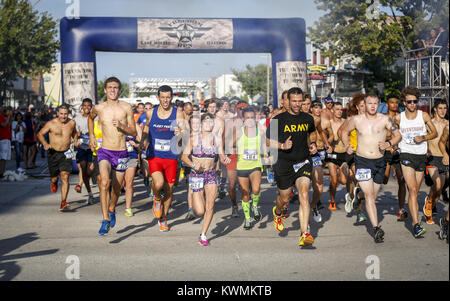 Davenport, Iowa, USA. Il 4° agosto 2016. Racers corrono attraverso il cannone di fumo all'inizio del 5k gara in fabbrica East Moline giovedì 4 agosto, 2016. La libertà eseguire 5k, che presentava un capretto ostacolo e un miglio di gara nonché il 5k stesso, si è svolta nel centro di East Moline come un vantaggio ai militari locali le famiglie. Credito: Andy Abeyta/Quad-City volte/ZUMA filo/Alamy Live News Foto Stock