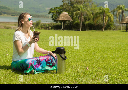 Donna bionda di bere il chimarrão tradizionale dallo stato di Rio Grande do Sul in Brasile. Cultura Gaúcha, Brasile. Foto Stock