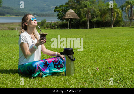 Donna bionda di bere il chimarrão tradizionale dallo stato di Rio Grande do Sul in Brasile. Cultura Gaúcha, Brasile. Foto Stock