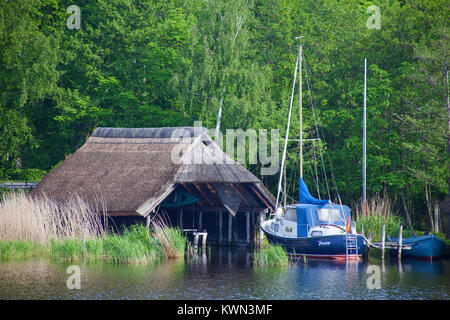 Barca a vela presso la casa-barca, Prerow Strom, Prerow, Fishland, Meclemburgo-Pomerania, Mar Baltico, Germania, Europa Foto Stock