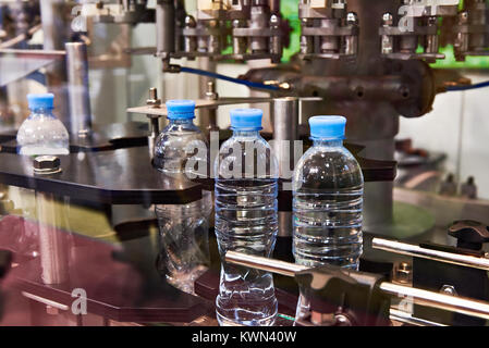 La linea di imbottigliamento di bevande in bottiglie di plastica in fabbrica Foto Stock