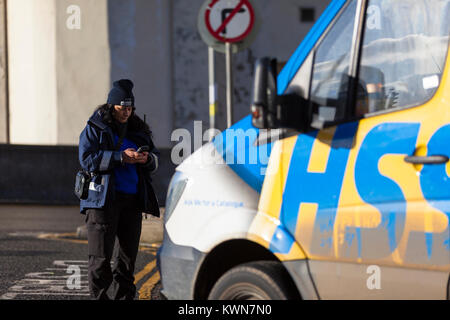 Una femmina di parcheggio enforcer emette un biglietto per un illegalmente parcheggiato van, Regno Unito Foto Stock