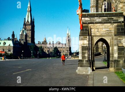 Un membro della Royal Canadian polizia montata, coloquially noto come un Mountie, passeggiate fra ornati edifici vicino al parlamento canadese, Ottawa, Ontario, Canada, 1950. Foto Stock