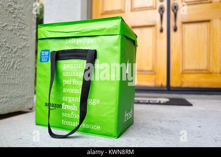 Green pack freddo tote per Amazon fresco servizio di consegna di generi alimentari, con Amazon logo e testo elenco di generi alimentari che possono essere ordinati tramite il servizio, sulla soglia di una casa suburbana in San Francisco Bay Area comune di San Ramon, California, 11 aprile 2017. Nel giugno del 2017, Amazon ha annunciato la sua intenzione di acquisire il grande catena di negozi di generi alimentari Whole Foods Market per ampliare la propria offerta nel negozio di generi alimentari industria. Foto Stock