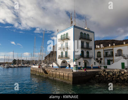 Puerto de Mogan, Gran Canaria in Spagna - Dicembre 16, 2017: Puerto de Mogan, persone in attesa per il traghetto al molo del traghetto, barche a vela in background. Foto Stock