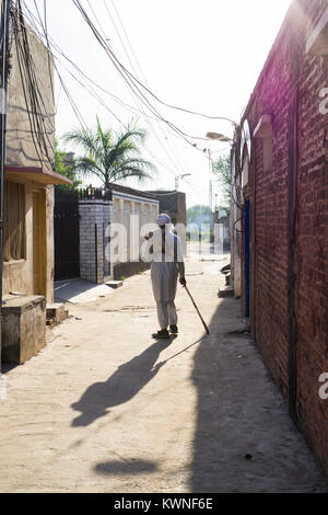 Vista posteriore di un vecchio uomo pakistano a camminare in un vicolo Foto Stock