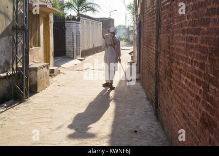 Vista posteriore di un vecchio uomo pakistano a camminare in un vicolo Foto Stock